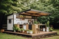 a tiny home with a full outdoor kitchen and dining area, surrounded by greenery Royalty Free Stock Photo