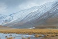 Tiny house, enormous mountain and pond in foregruond