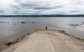 A man stands on a ramp at the edge of the Saguenay River in Quebec