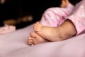 Tiny infant feet on lilac background, newborn legs at natural light