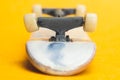 Tiny kateboard on yellow background. small skate for fingers. fingerboard close up