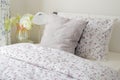 Tiny lavender pattern style bedding in bedroom with white orchid next to bed Royalty Free Stock Photo