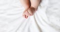 Tiny little feet. Baby`s feet lie on a white bed Royalty Free Stock Photo