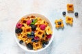 Tiny Mini waffles waffles with berries in a white bowl