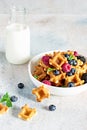 Tiny Mini waffles waffles with milk for breakfast with berries in a white bowl