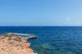 Tiny motorboat crosses waters of bay near Ibiza island, sea has a beautiful deep blue color, Balearic Islands, Spain Royalty Free Stock Photo