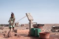 Tiny Native African Schoolgirl Bringing Tap Water in an arid zone