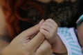 Tiny newborn baby arm in his mother`s palm in warm colors in soft focus background. Hands of mother and baby. Royalty Free Stock Photo