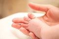 Tiny newborn baby foot in female hands. Royalty Free Stock Photo