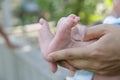 Tiny newborn baby foot in his mother`s palm in warm colors in soft focus background. Hands of mother and baby foot. Royalty Free Stock Photo