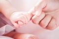 Tiny newborn baby hand holding mother finger with love Royalty Free Stock Photo