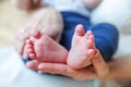 Tiny newborn infant male or female baby feet and toes on mother hand. Mother holding her newborn child. Family maternity, Royalty Free Stock Photo