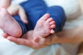 Tiny newborn infant male or female baby feet and toes on mother hand. Mother holding her newborn child. Family maternity, Royalty Free Stock Photo