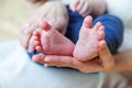 Tiny newborn infant male or female baby feet and toes on mother hand. Mother holding her newborn child. Family maternity, Royalty Free Stock Photo