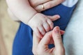 Tiny newborn infant male or female baby hand holding mother finger Royalty Free Stock Photo