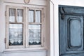 tiny old style vintage house facade with a wooden door and creamy color window with white embroidered curtains, aegean and Royalty Free Stock Photo