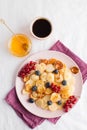 Tiny pancakes with berries, honey, coffee. Pancake cereal. The concept of Breakfast, food trends. Copy space