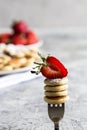 Tiny pancakes for breakfast. mini pancakes on a fork with strawberries