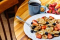 Tiny pancakes for breakfast. Pancakes with strawberries and blueberries cooked in the morning for breakfast in the home kitchen. Royalty Free Stock Photo