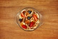 Tiny pancakes with strawberries and blueberries are in a bowl on a wooden table. Breakfast for children, trendy Breakfast, trendy