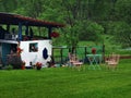 A tiny picnic combination of a table and four chairs standing on an emerald lawn