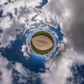 Tiny planet in blue sky with beautiful clouds. Transformation of spherical panorama 360 degrees. Spherical abstract aerial view. Royalty Free Stock Photo