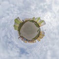 tiny planet in blue sky with clouds in city center near modern skyscrapers. Transformation of spherical 360 panorama in abstract Royalty Free Stock Photo