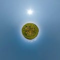 Tiny planet on dandelion field in blue sky with beautiful clouds. Transformation of spherical panorama 360 degrees. Spherical