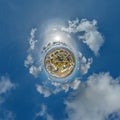 tiny planet in sky with clouds overlooking skyscrapers in new modern residential complex with high-rise buildings in town.