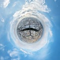 tiny planet in sky with clouds overlooking winter old town, urban development, historic buildings and crossroads with snow.