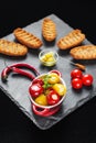 Tiny red and yellow hot peppers filled with cheese Balkan delicacy served with rusk, chilli peppers and cherry tomatoes Royalty Free Stock Photo