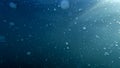 Tiny rising air bubbles lit by sun rays in clear blue sea water Royalty Free Stock Photo