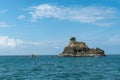 Tiny rocky island with a small tropical tree on top surrounded with blue sea water in Manzanillo, Costa Rica