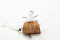 Tiny snowman on vintage wooden sled on snowy slope