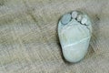 Tiny stone feet on sackcloth background Royalty Free Stock Photo
