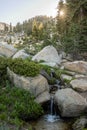 Tiny Stream Tumbles Over Rocks Below Sunburst