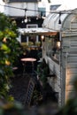 a tiny trailer with plants outside on the side of it