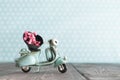 Tiny vintage toy blue motorcycle with bunch of pink flowers Royalty Free Stock Photo