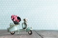 Tiny vintage toy blue motorcycle with bunch of pink flowers