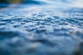 Tiny water bubbles on surface of blue wave macro Royalty Free Stock Photo