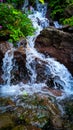 Tiny waterfall mountain spring water flowing through rocks Royalty Free Stock Photo