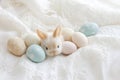 Tiny White Bunny Snuggled Among Painted Easter Eggs. Delicate Lace Background Enhances Elegance. Royalty Free Stock Photo