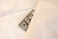 paying money dollar on white bed in hotel