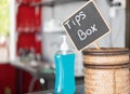 Tip box and hand sanitizer on table in restaurant Royalty Free Stock Photo