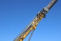 A Telescoping section of far-reaching crane is seen on a blue sky..