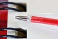 The tip of a red fountain pen on a white sheet of notepad with a spring. Time to study and business. Close-up. Macro