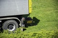 A tip truck on a grass field with a wheelbarrow filled with sand