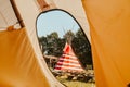 Tipi house in the forest against the background of trees, camping, village in the forest, camping. Indian teepee house at sunset