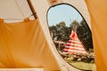 Tipi house in the forest against the background of trees, camping, village in the forest, camping. Indian teepee house at sunset