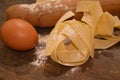 Tipical italian pasta pappardelle freh food homemade with eggs on table and kitchen utensils